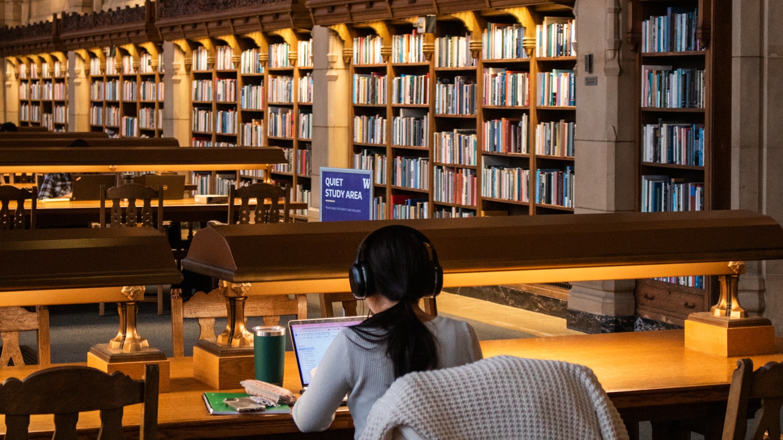 A student studying with headphones in a library